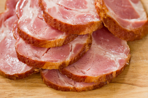 Spanish Jamon (Hamon), parma ham sliced on plate on white concrete table
