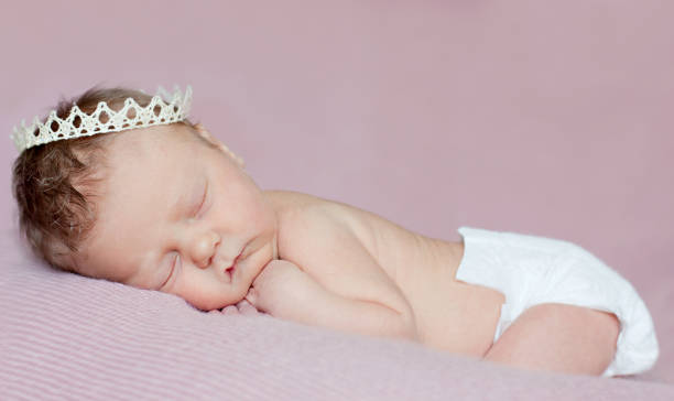 Newborn Princess. Baby girl sleeping with lace crown. stock photo