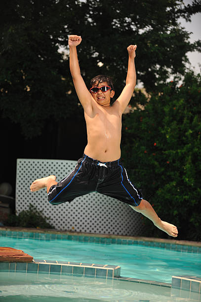 saut sur trampoline sur la piscine - descriptive color elementary student water blue photos et images de collection
