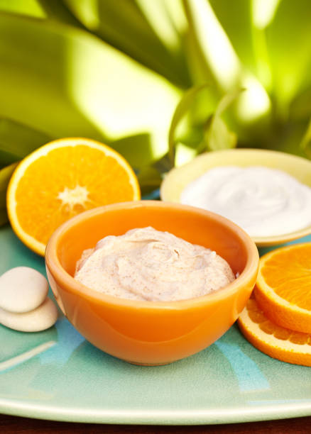 Spa exfoliation salt scrub, oranges and moisturizer on a plate