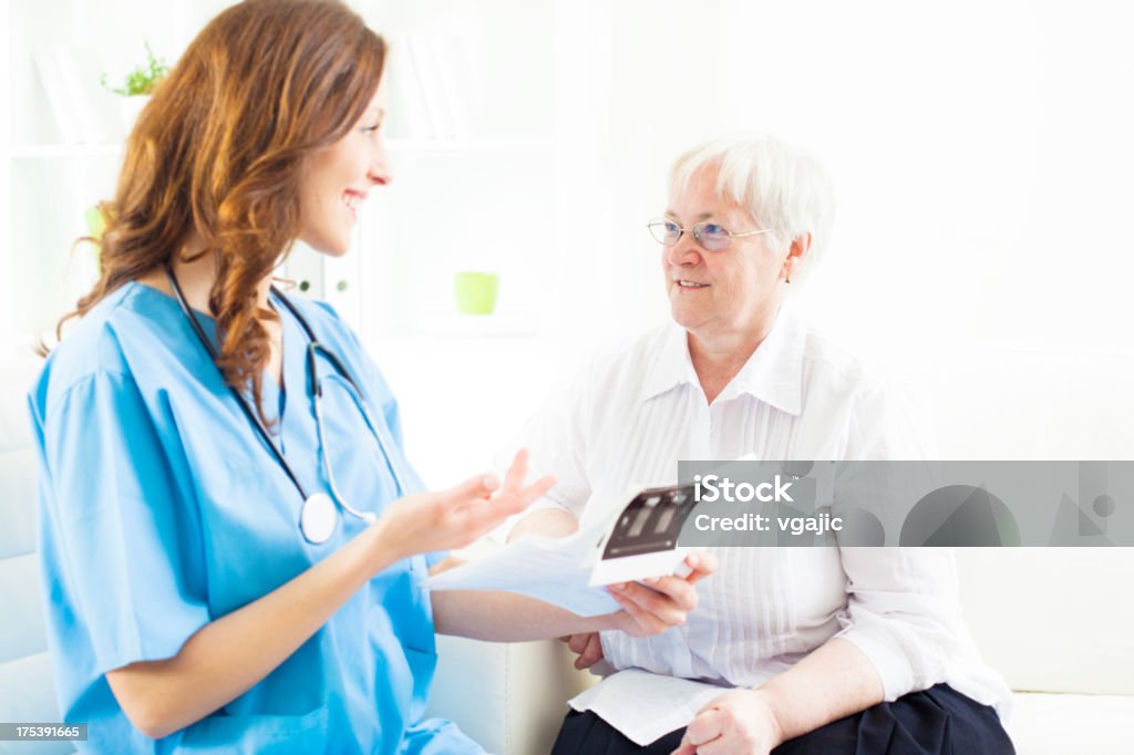 Donna anziana a medici in ufficio. - Foto stock royalty-free di 60-69 anni