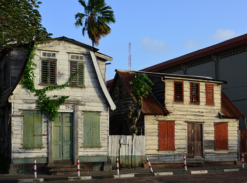 Paramaribo, Suriname: derelict façades of two 19th century colonial family houses in the old town,  among the few small wooden townhouses that still remaining, Malebatrumstraat