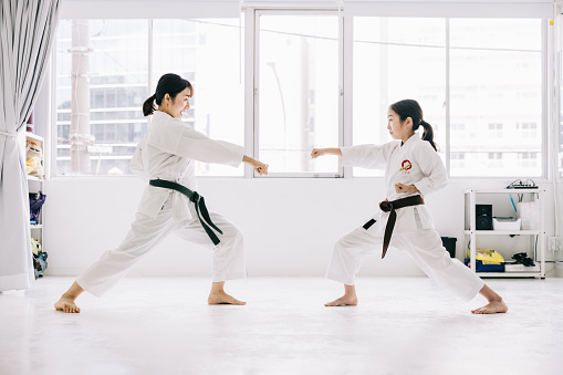 Karate students engage in a valuable exchange of knowledge and skills as they take turns demonstrating and receiving karate kicks, reinforcing the principles of respect and cooperation