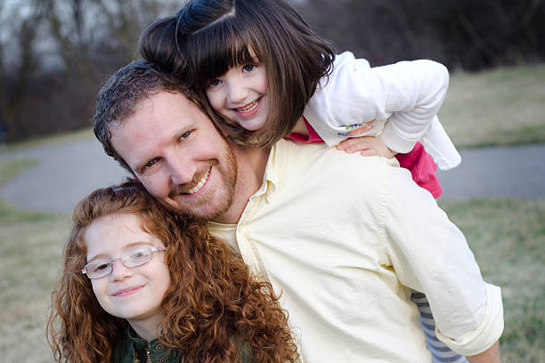 istock father and his daughters smile together 175392389