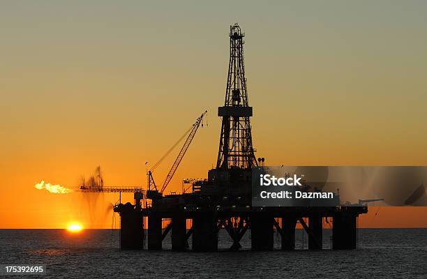 Photo libre de droit de Silhouette De Plateforme Pétrolière Dans Locéan Sur Le Coucher De Soleil banque d'images et plus d'images libres de droit de Plateforme offshore