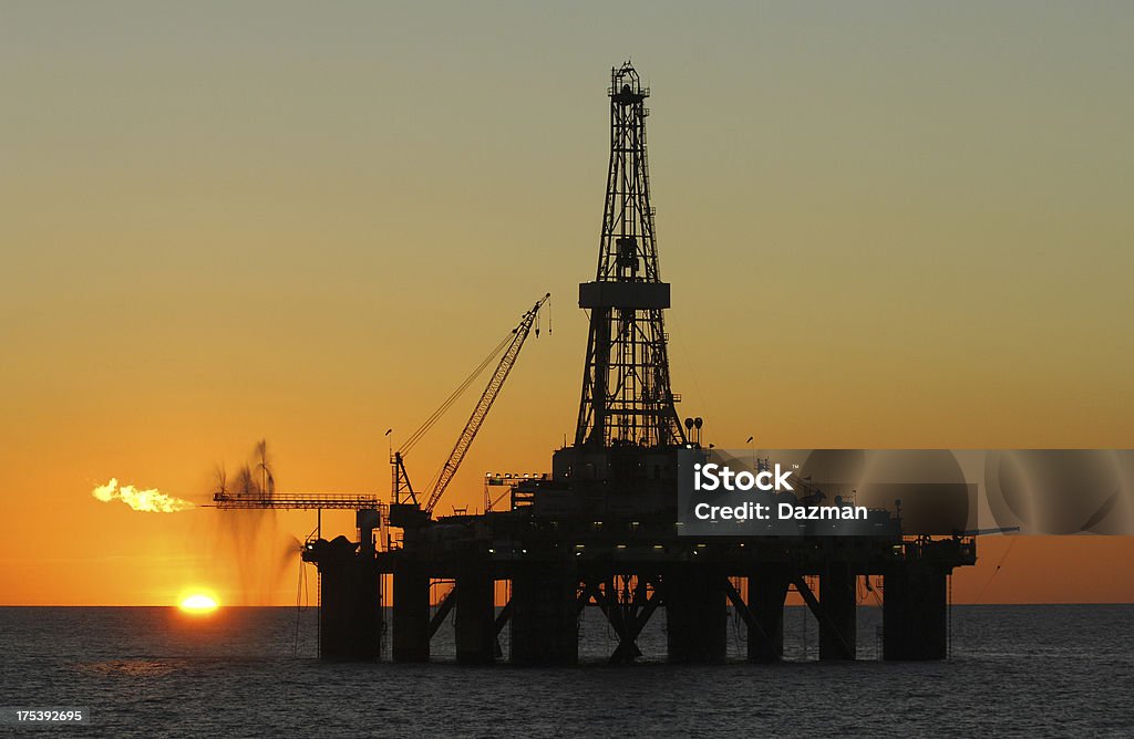 Ocean oil rig silhouette al tramonto. - Foto stock royalty-free di Piattaforma offshore