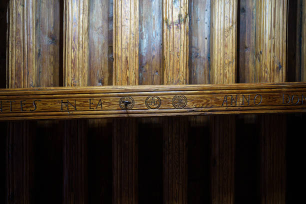 Antique larch ceiling beam with carved ornaments in the fireplace room of old tenement house