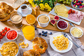 Healthy breakfast served with scrambled eggs, coffee, juice, croissants and fruits