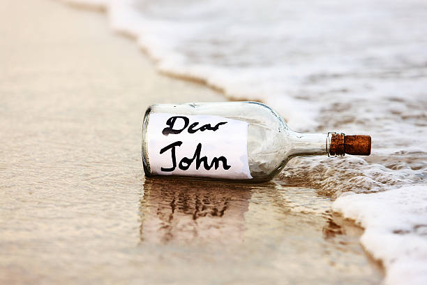 разрыв послание в бутылке на пляже — говорит дорогой john - stranded message in a bottle island document стоковые фото и изображения