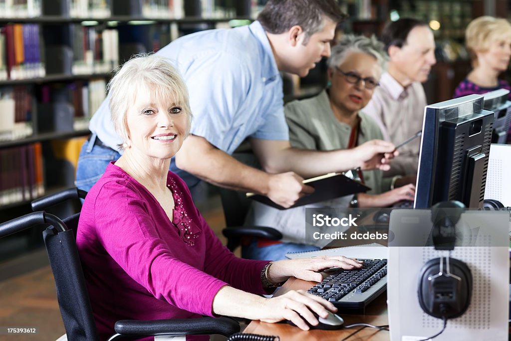 Uśmiechnięte Starsza kobieta z Wózek inwalidzki na komputerze w folderze Library - Zbiór zdjęć royalty-free (70-79 lat)