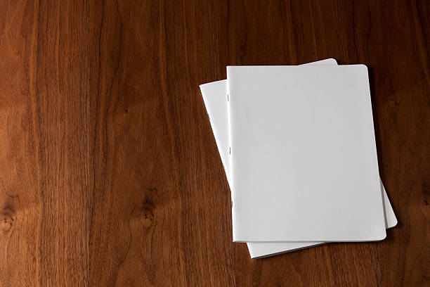 Two blank magazines on a wooden floor