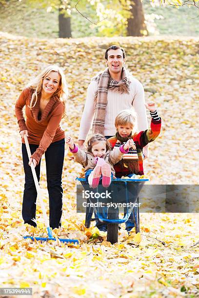 Young Family Raking Leaves Stock Photo - Download Image Now - Autumn, Rake, Women