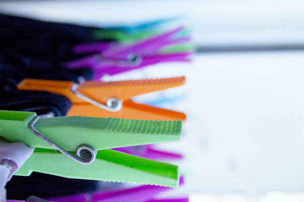 Clothespins holding clothes on clothesline. Various colors. No people