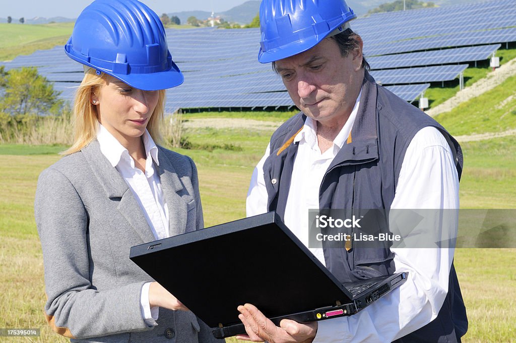 Two EngineersPlanning PC in a Solar Power Station Two engineers in a solar panel station Adult Stock Photo