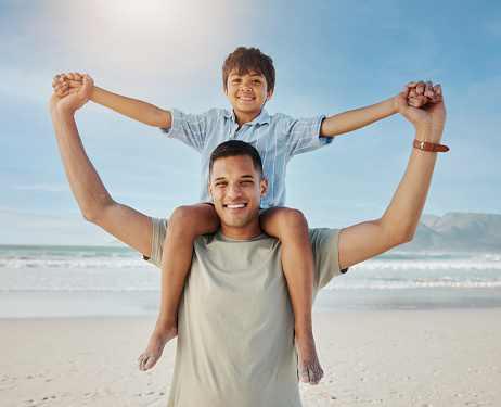Portrait of father, child on shoulders and beach, smile together in summer waves on tropical island holiday in Hawaii. Fun, dad and boy on ocean vacation with love, support and relax with blue sky.