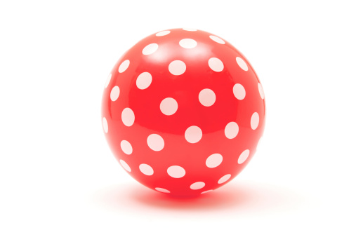 Red ball with white dots isolated on a white background.