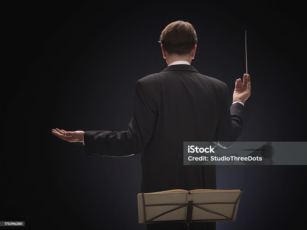 conductor Series of middle age conductor isolated over dark background Musical Conductor Stock Photo