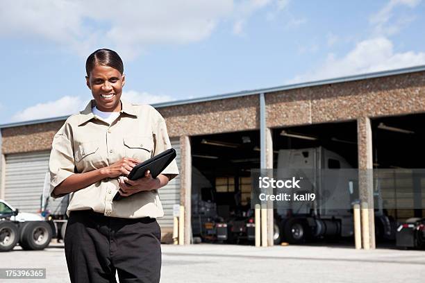 Photo libre de droit de Femme Travailleur Au Centre De Transport De Marchandises Par Route banque d'images et plus d'images libres de droit de Garage automobile