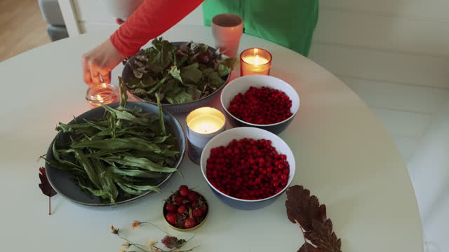 Woman Making Homemade Herbal Tea with Berries at Home