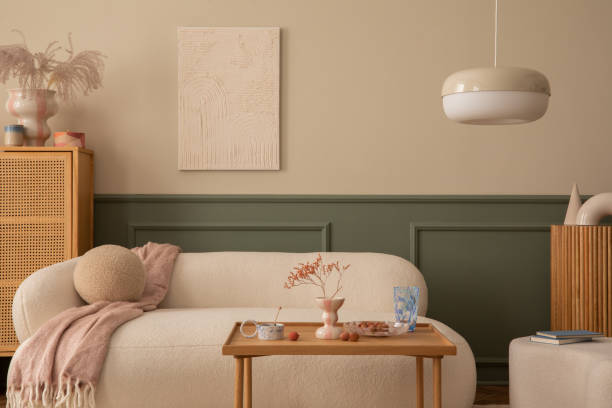温かみのある居心地の良いリビングルームのインテリアには、モックアップポスターフレーム、ブークレソファ、籐のサイドボード、木製のコーヒーテーブル、ピンクのチェック柄、花瓶、� - showcase interior home decorating chair pink ストックフォトと画像