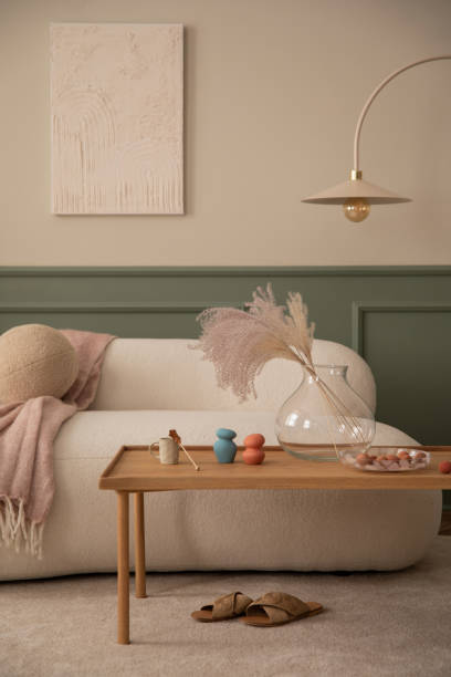 モックアップポスターフレーム、木製のコーヒーテーブル、枕、ピンクのチェック柄、ドライフラワーの花瓶、ベージュの敷物、ランプ、パーソナルアクセサリーを備えたリビングルームの� - showcase interior home decorating chair pink ストックフォトと画像