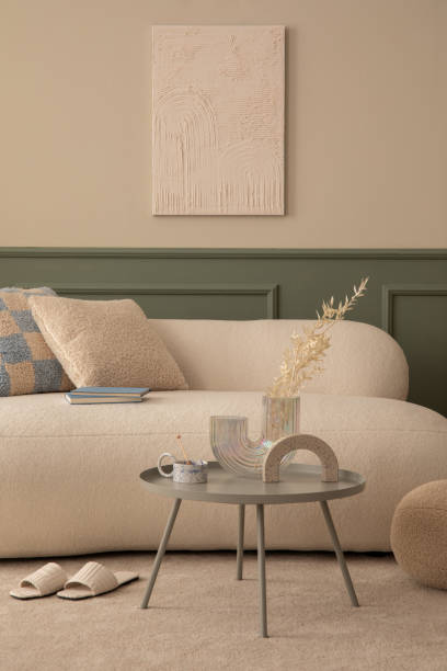 istock Warm living room inerior with mock up poster frame, boucle sofa, patterned pillows, round coffee table, vase with dried flowers, round pillow and personal accessories. Home decor. Template. 1753964522