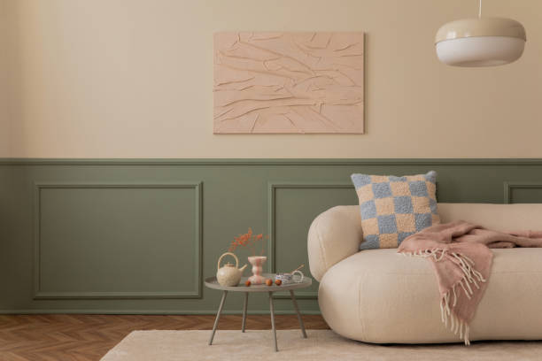 Living room interior with mock up poster frame, copy space, boucle sofa, patterned pillow, round coffee table, pink plaid, beige rug and personal accessories. Home decor. Template.