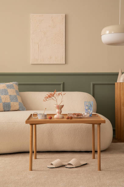 温かみのある居心地の良いリビングルームのインテリアには、モックアップポスターフレーム、木製のコーヒーテーブル、模様入りの枕、ピンクのチェック柄、白いスリッパ、ベージュのラ� - showcase interior home decorating chair pink ストックフォトと画像