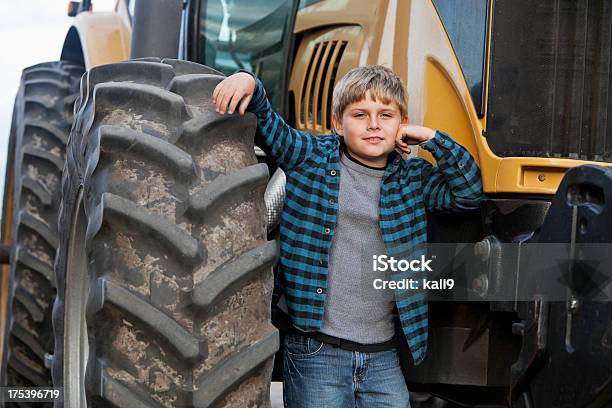 Boy Standing In Front Of Tractor Stock Photo - Download Image Now - Boys, Standing, Tractor