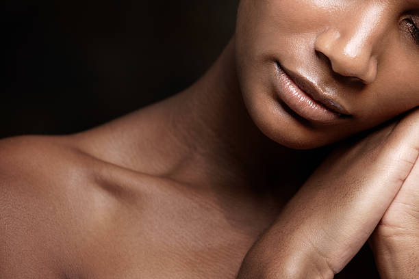 Feel of soft, silky skin on her hands Cropped image of an african beauty with flawless skin sleeping against a black background semi dress stock pictures, royalty-free photos & images