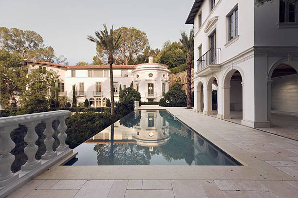 Exterior photo of a Bel Air mansion featuring a pool Early morning sunlight shines on a large estate home in Bel Air California. los angeles county stock pictures, royalty-free photos & images