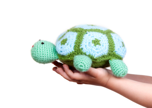 little girl holding knitted turtle
