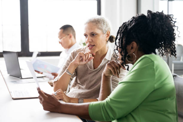 istock Female colleagues in their 50s discussing document 1753983127