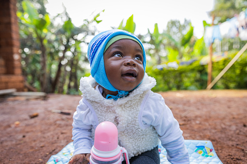 Lindo y hermoso bebé africano mirando sonriente al cielo photo