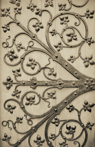 Monochrom photograph of iron ornaments on a wooden church door.
