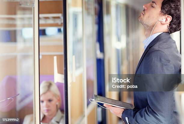 Businessman With Headphones And Digital Tablet Relaxing On Passenger Train Stock Photo - Download Image Now