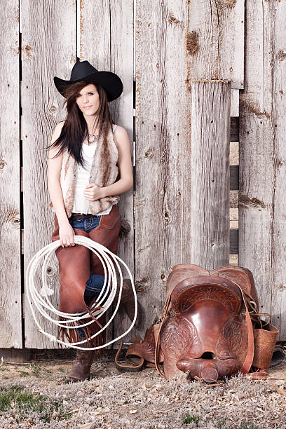 western cowgirl y saddle contra madera rústica valla - idaho beautiful western usa usa fotografías e imágenes de stock