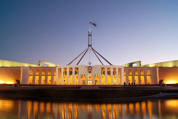 Image of Parliament House with reflection in water Parliament House in Canberra, Australia, illuminated at dusk. house of representatives photos stock pictures, royalty-free photos & images