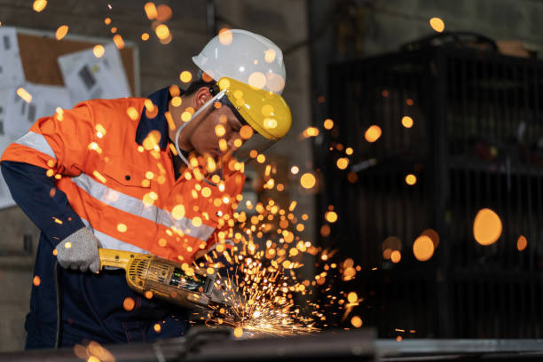 istock Mechanical engineer in protective gear shows the epitome of skill and precision. With a grinding tool in hand, they sculpt a piece of steel into a masterpiece, all against the backdrop of workshop at factory. Display of sparks scattered firework. 1754002995