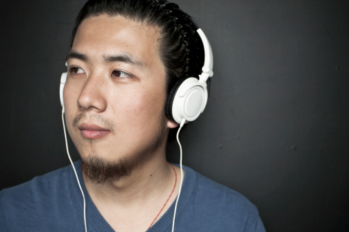 Portrait of an asian young man indoors.wearing earphone