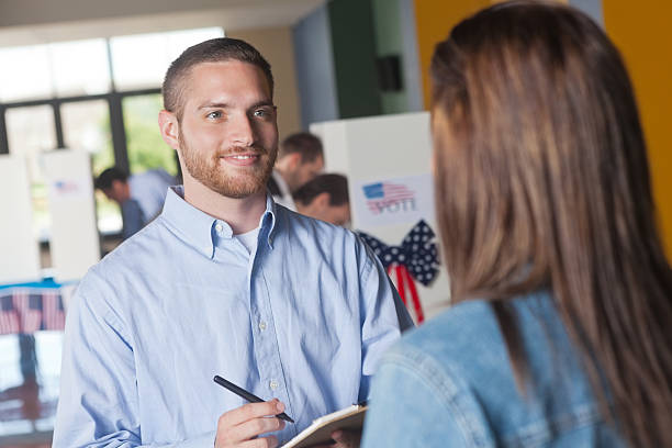 istock Happy volunteer asking exit poll questions at election voting center 175401194