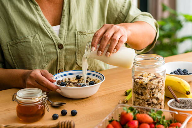 istock Woman adding milk to a bowl preparing healthy meal 1754015745