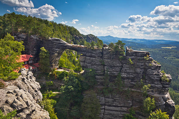 The Pravcicka brana "The Pravcicka brana, Bohemian Switzerland, Czech Republic. The narrow rock formation is the largest natural sandstone arch in Europe. With a span of 26.5 metres, an inside height of 16 metres, 8 metre maximum width and 3 metre arch it is one of the most striking natural monuments in the Elbe Sandstone Mountains.See more MOUNTAINS images here:" pravcicka stock pictures, royalty-free photos & images