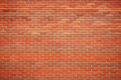 smooth brick wall in a pale orange hue with dark seams between rectangular blocks, blank background of plain brickwork with space to insert, brick wall fragment graphic resource