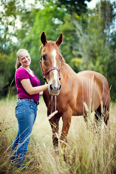 istock Young Woman With Horse In Pasture 175402567