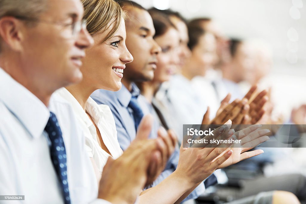 Grupo de empresários sentado em uma linha e a aplaudir. - Foto de stock de Aplaudindo royalty-free