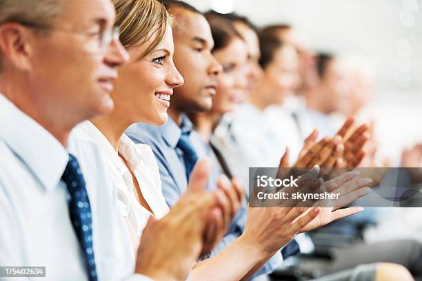 Grupo De Empresários Sentado Em Uma Linha E A Aplaudir - Fotografias de stock e mais imagens de Aplaudir