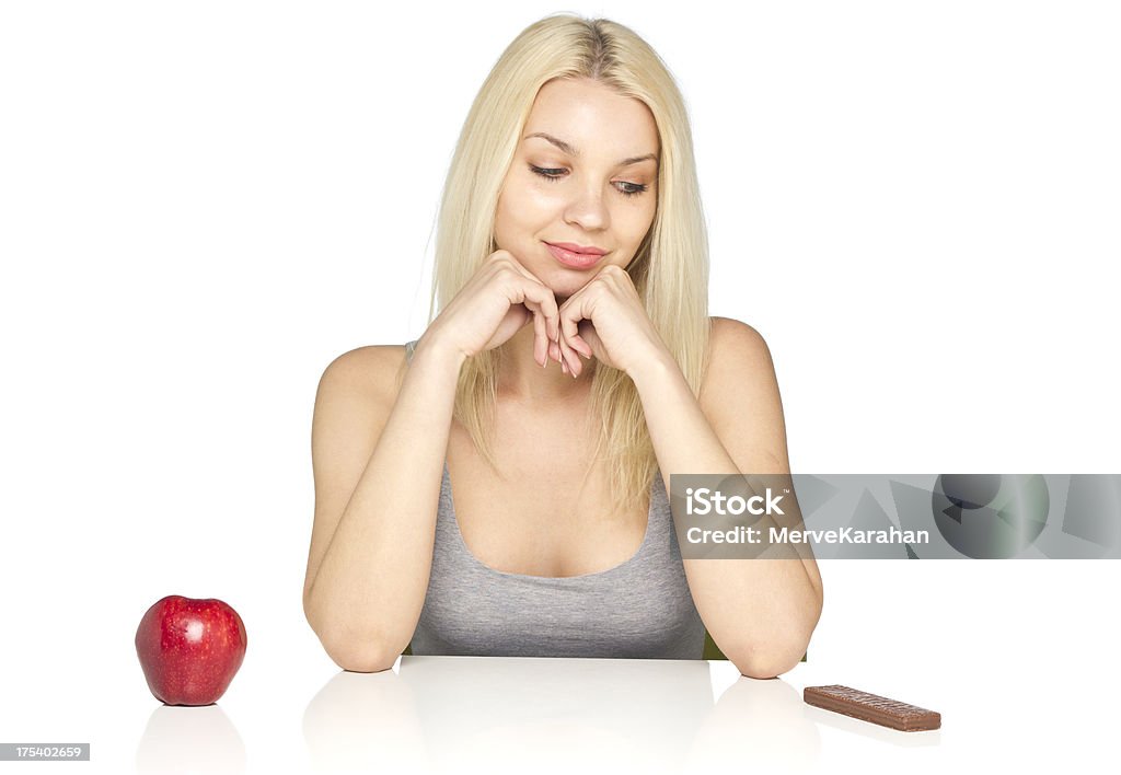 Healthy eating A studio shot of an attractive woman can't decide what to eat. Adult Stock Photo