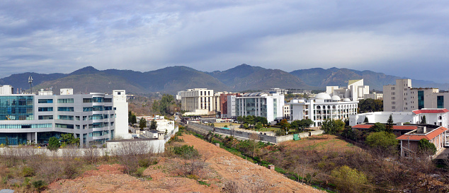 Islamabad, Pakistan: Pakistani capital cityscape - left to right: National Telecommunication Corporation Headquarters, Federal Board of Revenue, Federal Ombudsman (Wafaqi Mohtasib), Auditor General of Pakistan, President House, Federal Shariat Court, Supreme Court of Pakistan, Pakistan Academy of Sciences, Election Commission of Pakistan, Comstech - Institutional Area. In the background the Margalla Hills, part of the Himalayan foothills.