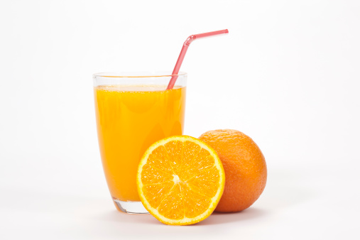 Glass of orange juice and fresh tangerine fruits with leaves